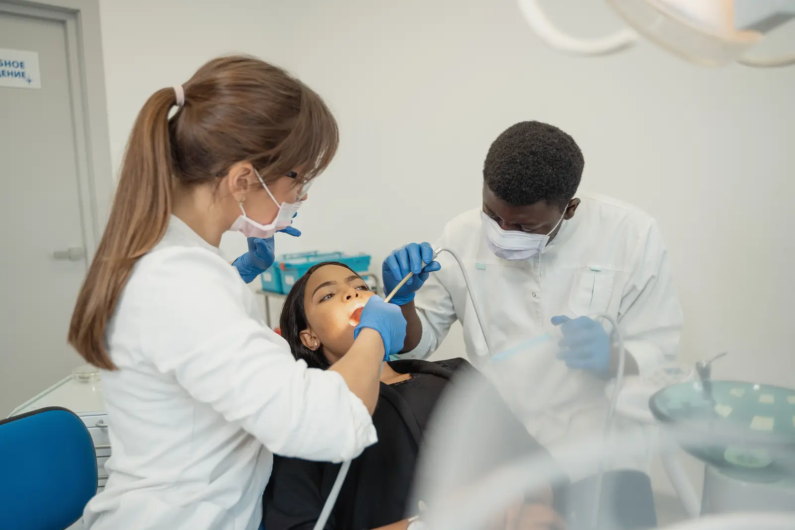 Dental clinicians caring for a patient in a modern treatment room