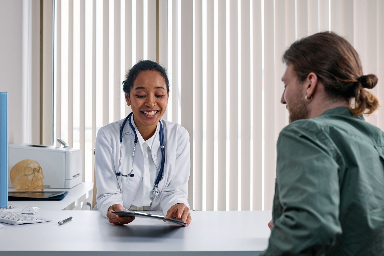 A doctor and patient talking across a consultation desk